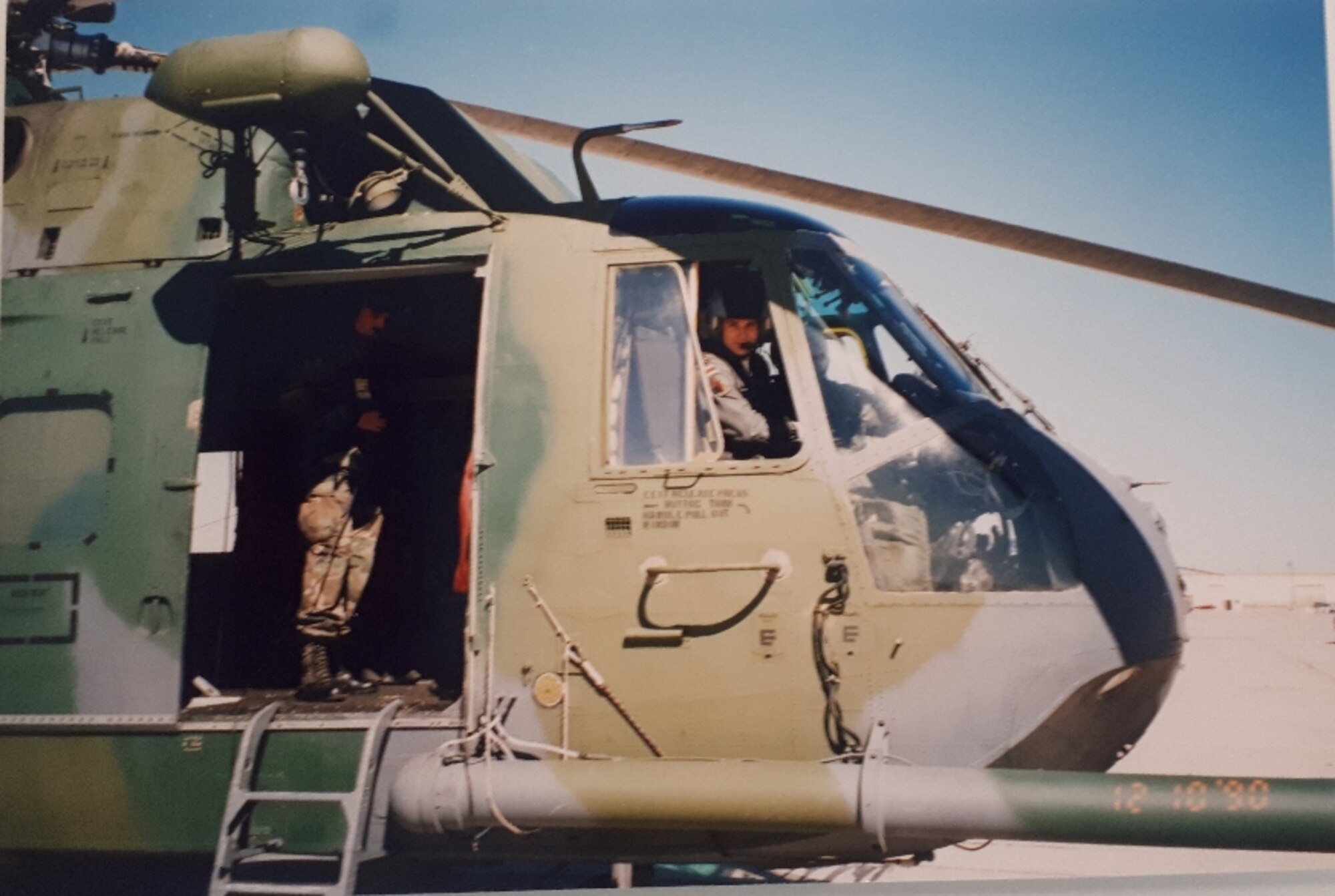 Man sitting inside a helicopter looking out.