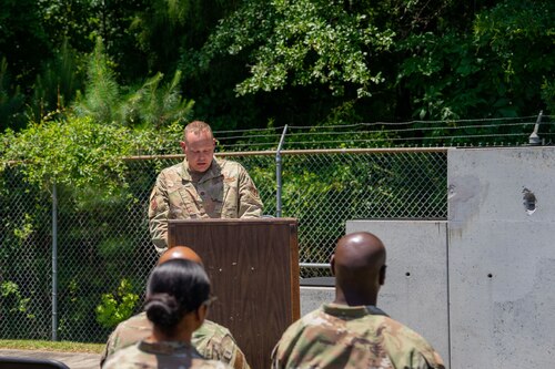 Man in military uniform stands at podium while speaking