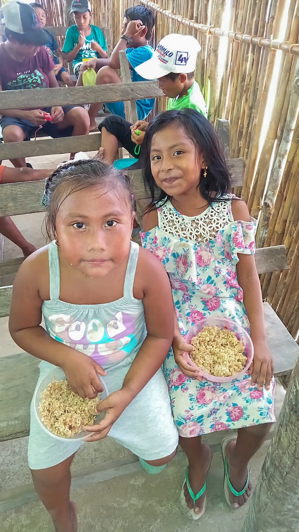 Two Panamanian girls in a rural village eat food delivered to Panama under the Department of Defense's Denton Humanitarian Assistance Program, June 1, 2024.