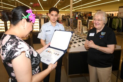 Ms. Caryl Hill, Employer Support of the Guard and Reserve, Southern Region director, presents Ms. Nancy Olguin, Sunglass Hut manager, with the Seven Seals Award, April 19, 2024 at the Sunglass Hut® store at the Base Exchange on Joint Base San Antonio-Fort Sam Houston, Texas.