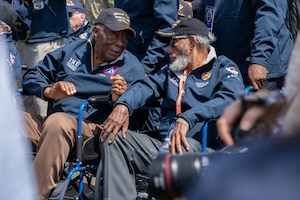 Two veterans sit and chat outdoors.