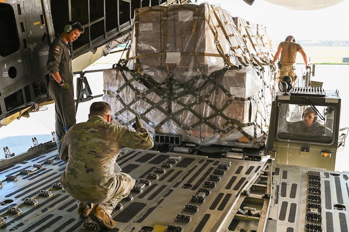 Staff Sgt. Thomas Riojas and Master Sgt. Brent Bolin, 68th Airlift Squadron loadmasters, guide 72nd Airbase Wing Airmen in lining up a K-Loader with the ramp of a 433rd Airlift Wing C-5M Super Galaxy at Tinker Air Force Base, Oklahoma May 31, 2024.