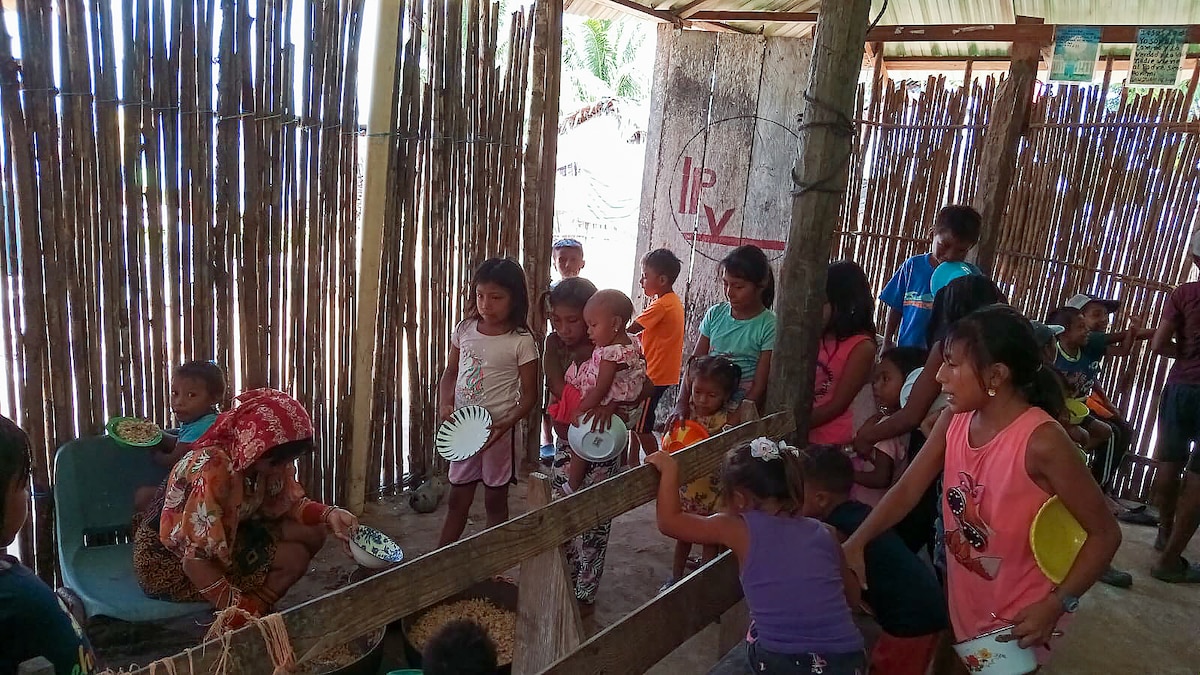 Panamanian children in a rural village on the San Blas Islands, Guna Yala district line up to eat food delivered to Panama, under the Department of Defense's Denton Humanitarian Assistance Program June 1, 2024.