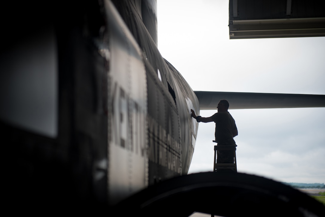 Master Sgt. Lee Stanley, aircraft structural shop chief for the 123rd Maintenance Squadron, applies decals to a C-130J Super Hercules at the Kentucky Air National Guard Base in Louisville, Ky., May 15, 2024, to replicate historical aircraft markings used on U.S. aircraft during World War II. The aircraft is scheduled to patriciate in D-Day observations in France on June 6 bearing the unique livery. (U.S. Air National Guard photo by Airman 1st Class Annaliese Billings)