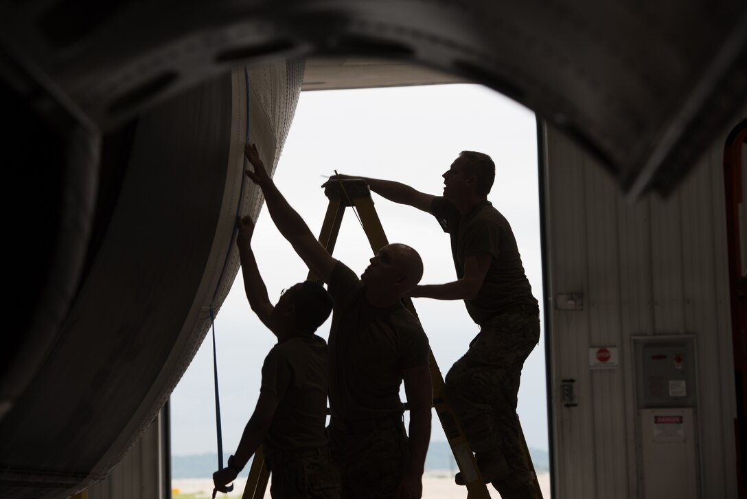 Aircraft structural craftsmen from the Kentucky Air National Guard’s 123rd Maintenance Squadron align tape to the side of a C-130J Super Hercules prior to painting stripes on the aircraft in Louisville, Ky., May 14, 2024. The stripes, to be placed on the belly and wings, represent the livery used by U.S. aircraft during World War II. The Kentucky plane is slated to participate in an exercise in France on June 6 as part of a D-Day observations while displaying the historic markings. (U.S. Air National Guard photo by Airman 1st Class Annaliese Billings)