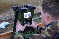 Warfighter adjusts settings on a chemical vapor detector.