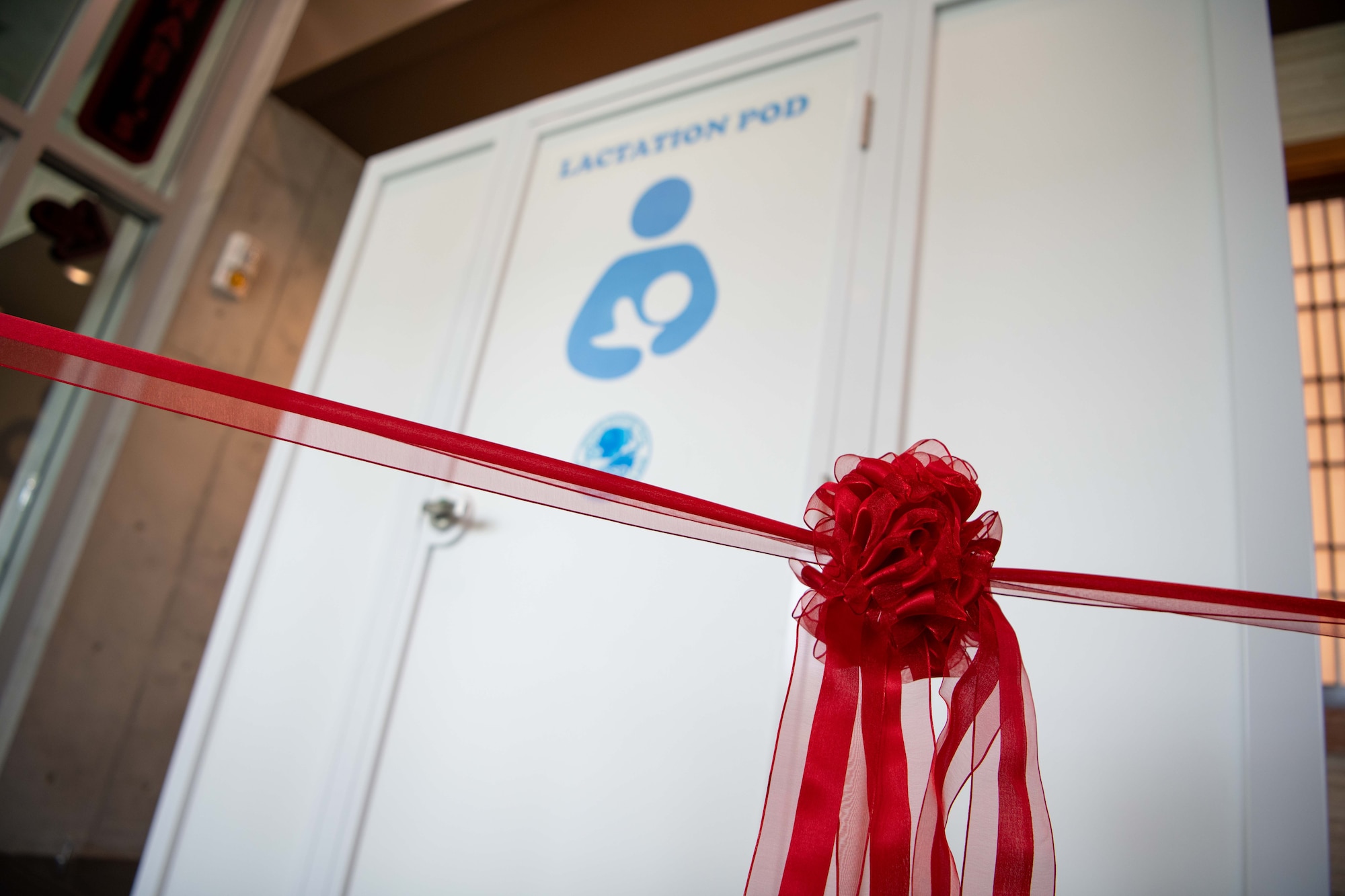 a red ribbon hangs tied in front of a lactation pod