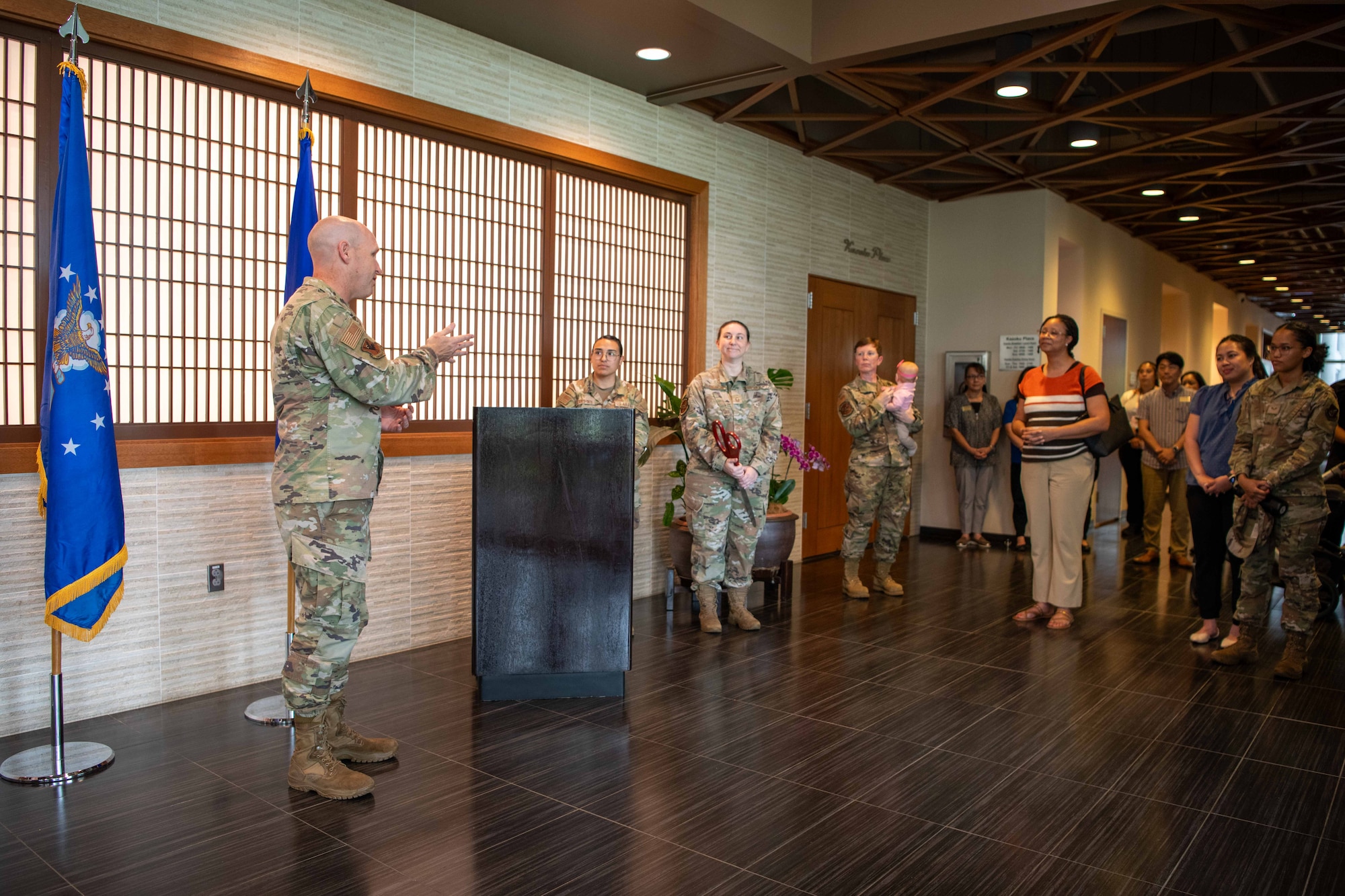 military member speaks in front of a crowd next to a podium