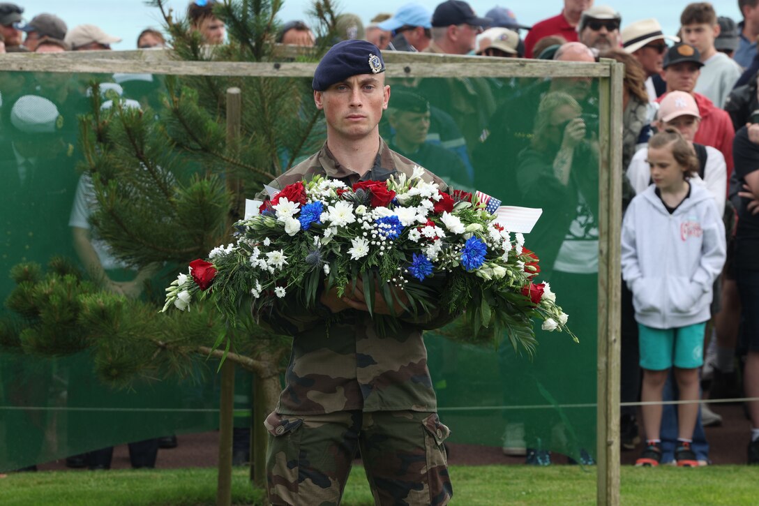 A French soldier stands with a wreath during the D-Day Memorial Ceremony at the Normandy American Cemetery in Normandy, France, June 4, 2024. U.S. Marines and sailors with 24th Marine Expeditionary Unit and members of France's 9th Marine Infantry Brigade (BIMa) gathered to commemorate the 80th anniversary of the largest amphibious operation in history. In 1944, the U.S. Army invaded the beaches of Normandy to begin the liberation of France. (U.S. Marine Corps photo by Lance Cpl. Garrett Gillespie)