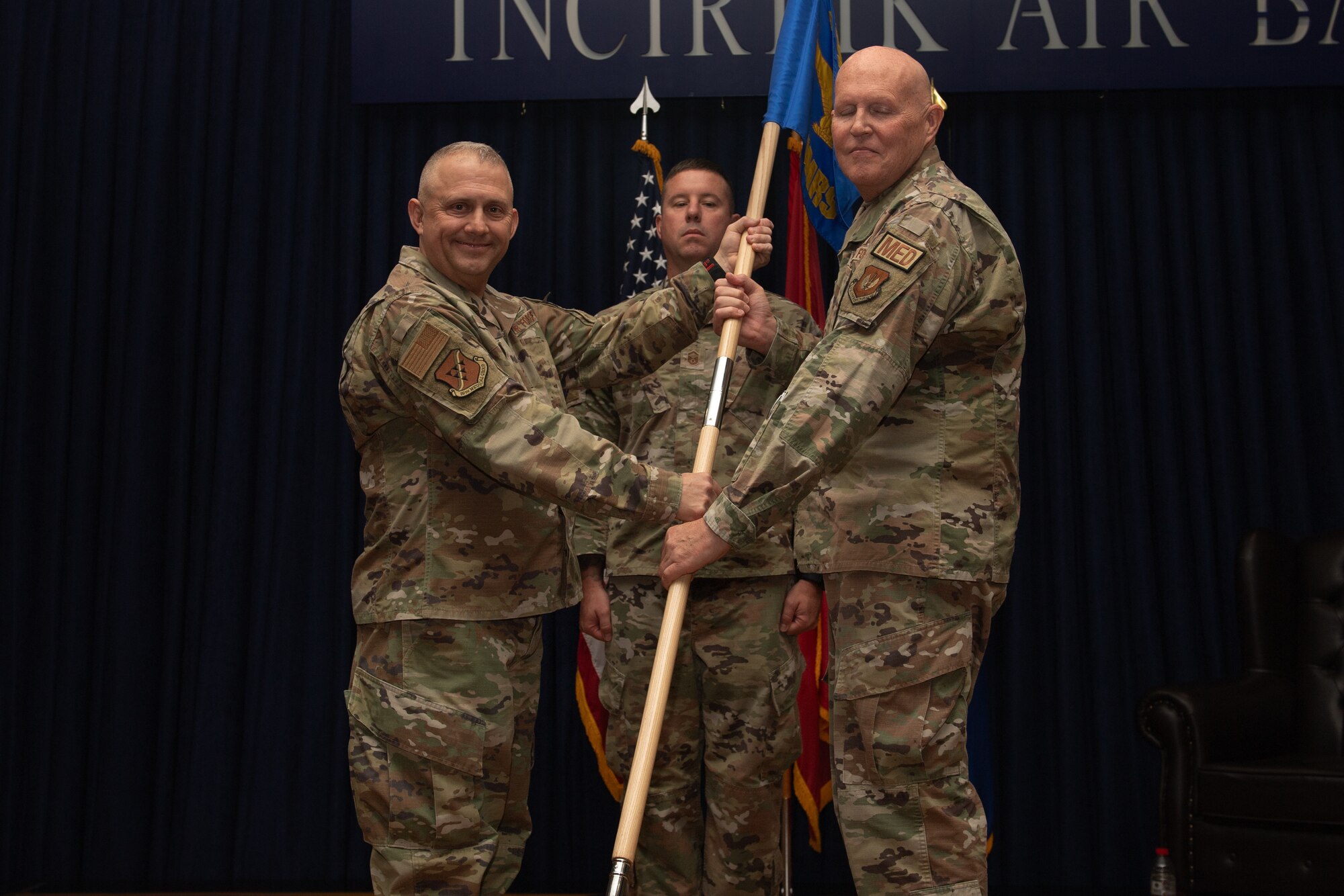 U.S. Air Force Col. Robert Rainey, 39th Medical Group commander, passes the guidon to Lt. Col Richard Odosso, 39th Operational Medical Readiness Squadron commander, during a change of command ceremony.