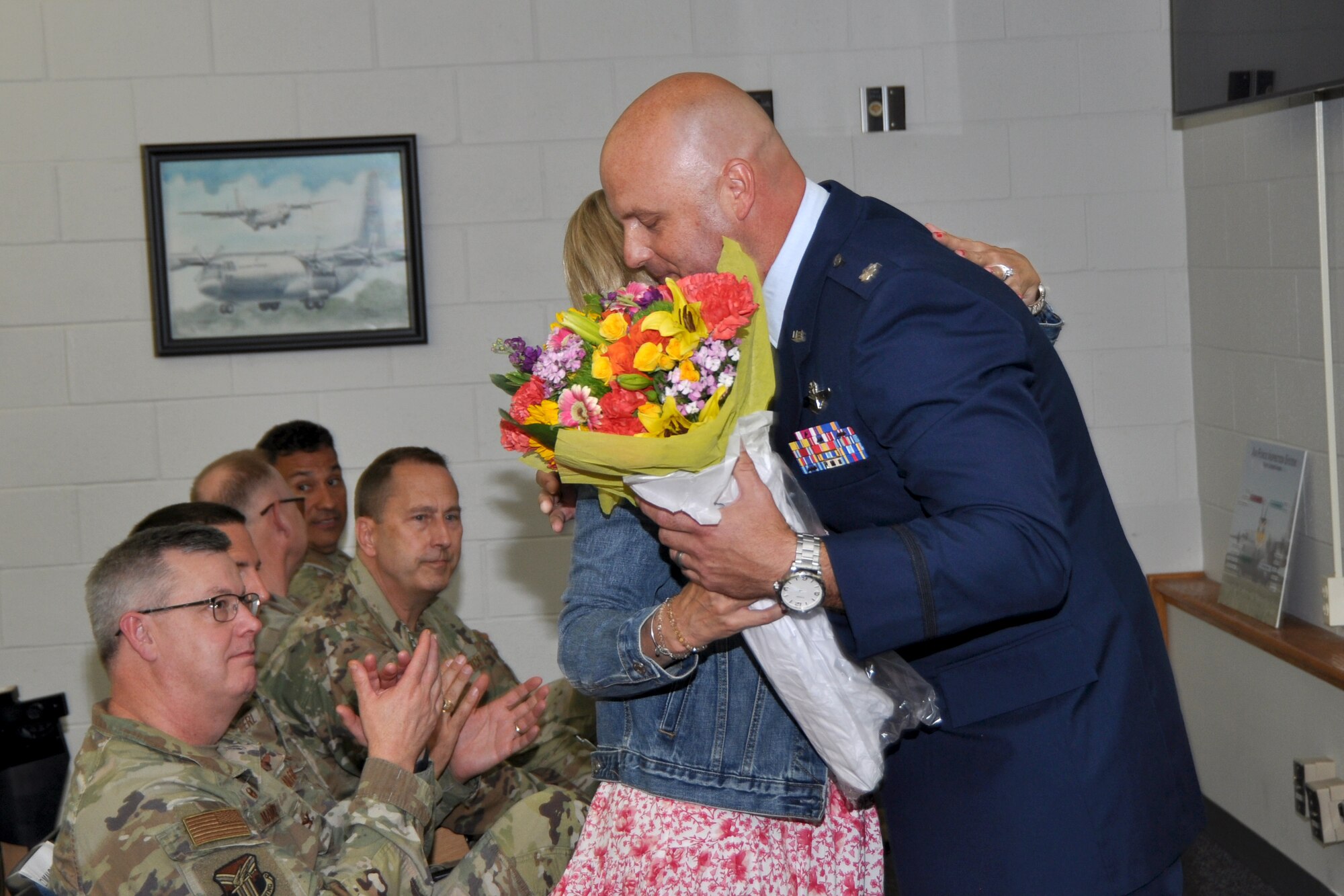Lt. Col. Brian Hodor, 757th Airlift Squadron commander, hugs his wife, Jill, while presenting her flowers following his remarks during an Assumption of Command ceremony, held in the 910th Operations Group Aircrew Briefing room at Youngstown Air Reserve Station, Ohio, June 1, 2024.