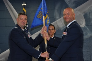 Col. John Sebesta, 910th Operations Group commander, and Lt. Col. Brian Hodor, 757th Airlift Squadron commander, hold the squadron’s guidon while Master Sgt.