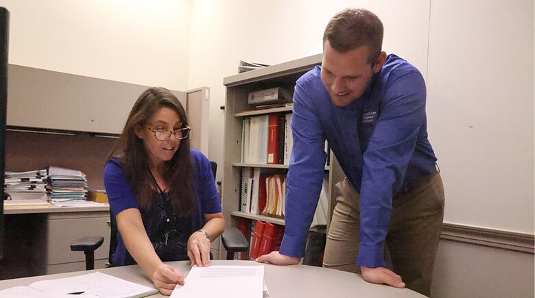 Woman and Man looking over documents at a desk.