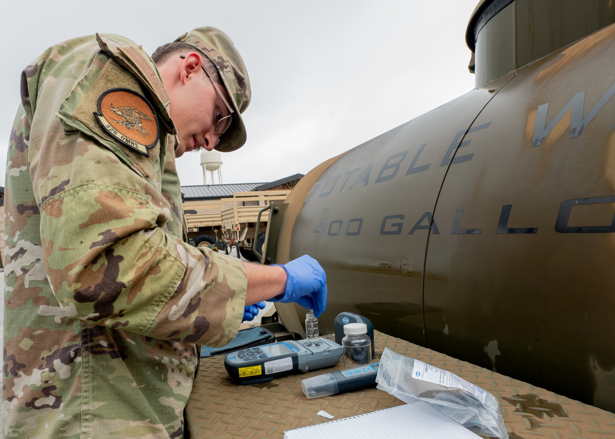 a bioenvironmental engineering technician checks chlorine levels in water samples taken from a water buffalo