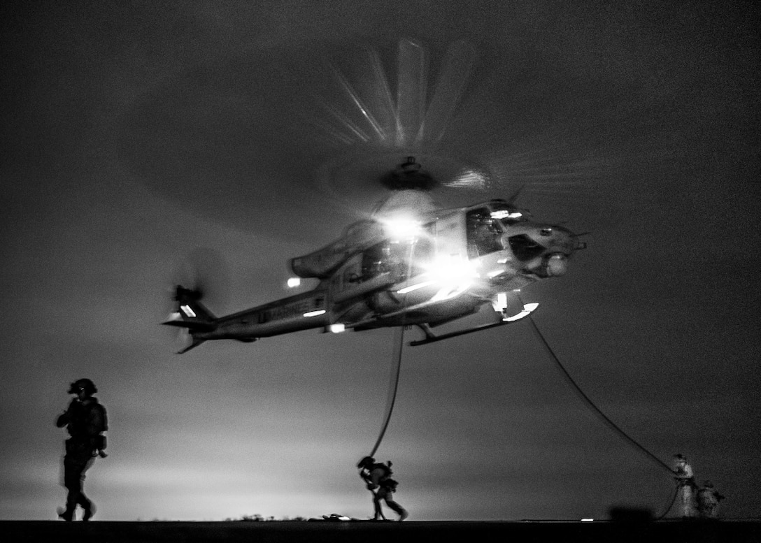 U.S. Marines and Sailors assigned to Reconnaissance Company, 15th Marine Expeditionary Unit, fast-rope from a UH-1Y Venom attached to Marine Medium Tiltrotor Squadron (VMM) 165 (Reinforced), 15th MEU, during sustainment training at Marine Corps Base Camp Pendleton, California, May 30, 2024. Fast-roping provides Marines with the ability to conduct helicopter insertions to areas where helicopter landings are impractical. (U.S. Marine Corps photo by Cpl. Joseph Helms)