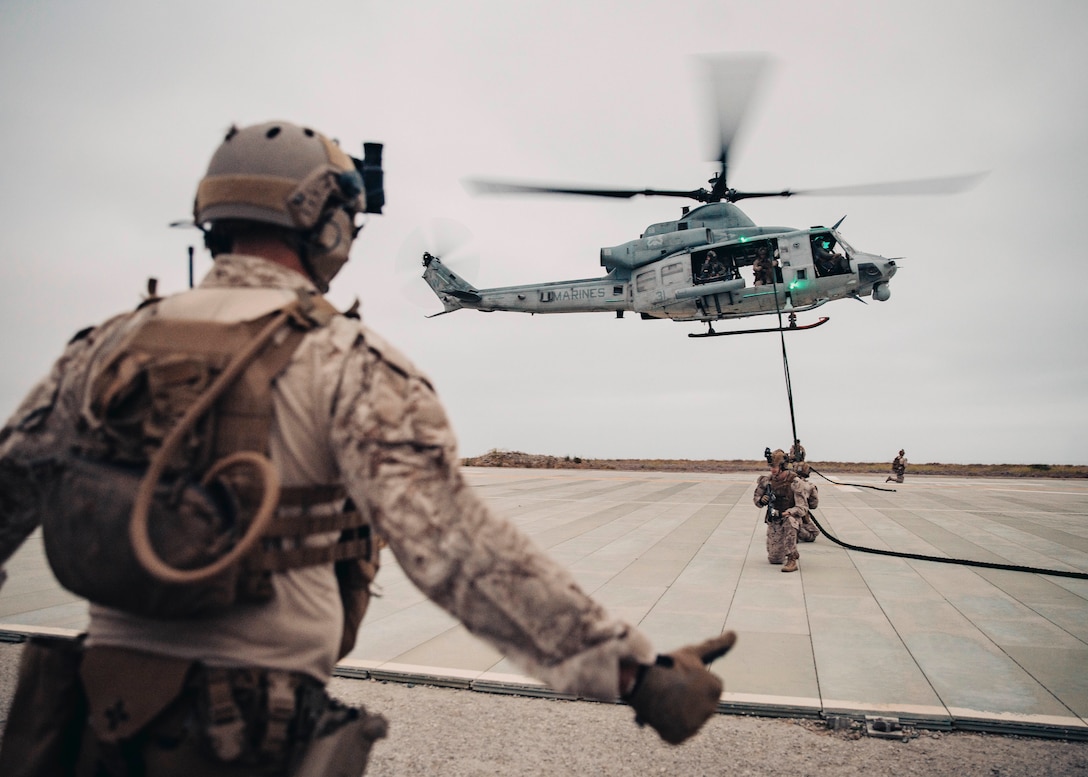 U.S. Marines and Sailors assigned to Reconnaissance Company, 15th Marine Expeditionary Unit, fast-rope from a UH-1Y Venom attached to Marine Medium Tiltrotor Squadron (VMM) 165 (Reinforced), 15th MEU, during a sustainment training at Marine Corps Base Camp Pendleton, California, May 30, 2024. Fast-roping provides Marines with the ability to conduct helicopter insertions to areas where helicopter landings are impractical . (U.S. Marine Corps photo by Cpl. Joseph Helms)