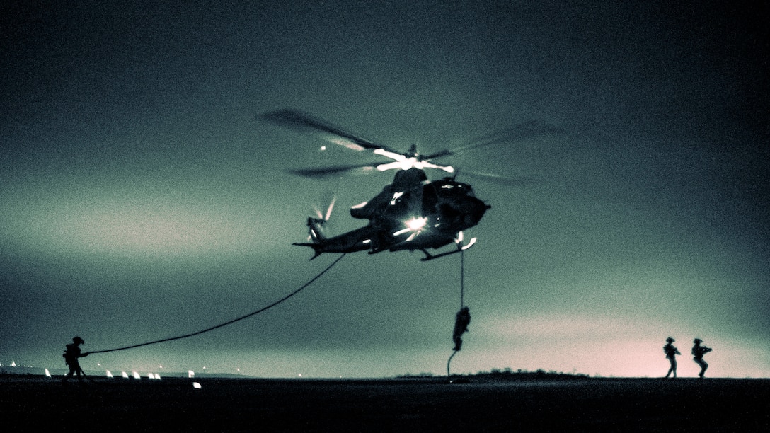 U.S. Marines and Sailors assigned to Reconnaissance Company, 15th Marine Expeditionary Unit, fast-rope from a UH-1Y Venom attached to Marine Medium Tiltrotor Squadron (VMM) 165 (Reinforced), 15th MEU, during sustainment training at Marine Corps Base Camp Pendleton, California, May 30, 2024. Fast-roping provides Marines with the ability to conduct helicopter insertions to areas where helicopter landings are impractical. (U.S. Marine Corps photo by Cpl. Joseph Helms)