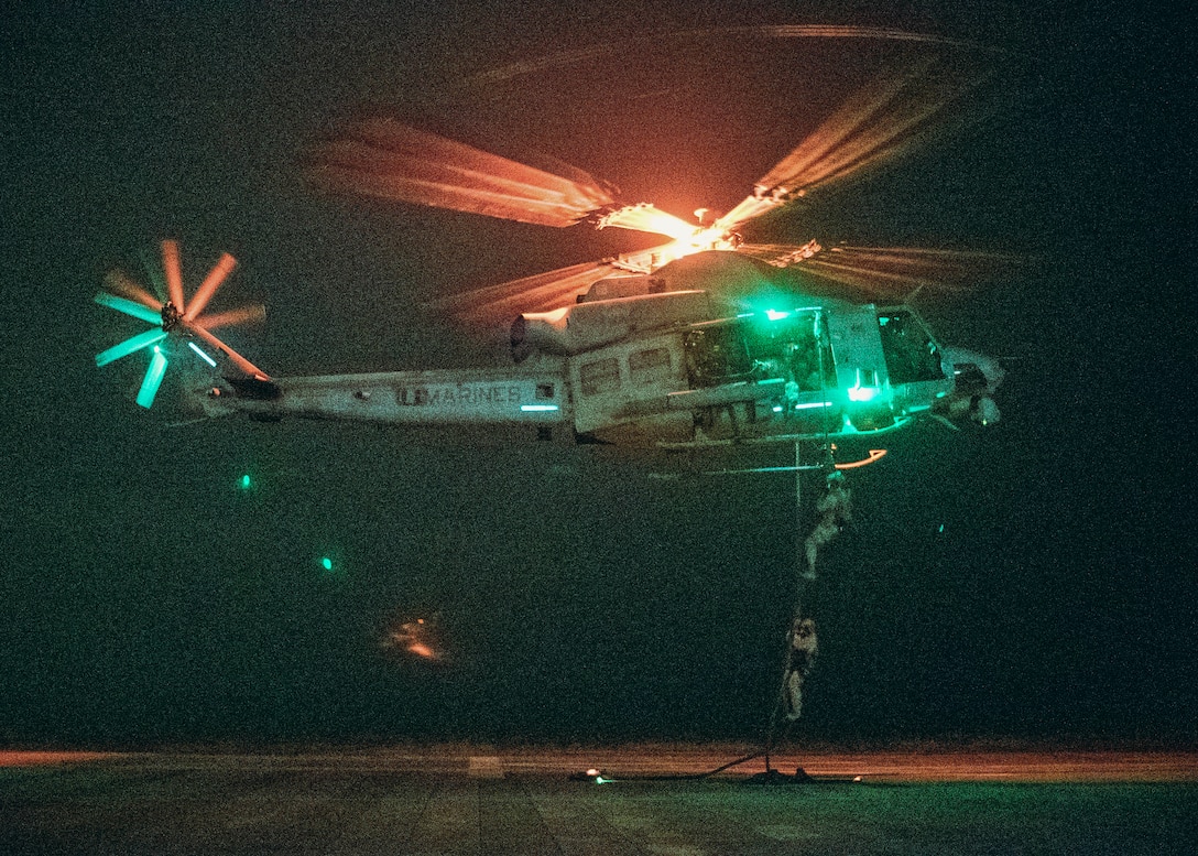 U.S. Marines and Sailors assigned to Reconnaissance Company, 15th Marine Expeditionary Unit, fast-rope from a UH-1Y Venom attached to Marine Medium Tiltrotor Squadron (VMM) 165 (Reinforced), 15th MEU, during sustainment training at Marine Corps Base Camp Pendleton, California, May 30, 2024. Fast-roping provides Marines with the ability to conduct helicopter insertions to areas where helicopter landings are impractical. (U.S. Marine Corps photo by Cpl. Joseph Helms)