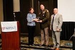 Leigh Method, Deputy Assistant Secretary of Defense for Logistics, presents Army Lt. Col. Timothy Owens, commander, Defense Logistics Agency Distribution Corpus Christi, and Jeremy Beckwith, deputy commander, DDCT, the 2023 the National Institute of Packaging, Handling and Logistics Engineers Corporate/Agency of the Year Award on behalf of the DDCT Preservation, Packaging, Packing and Marking Team. Beckwith also received a Logistics Lifetime Achievement Award for his contributions to the DoD logistics enterprise via his technical expertise and selfless leadership during his 28-year military and civilian career.
