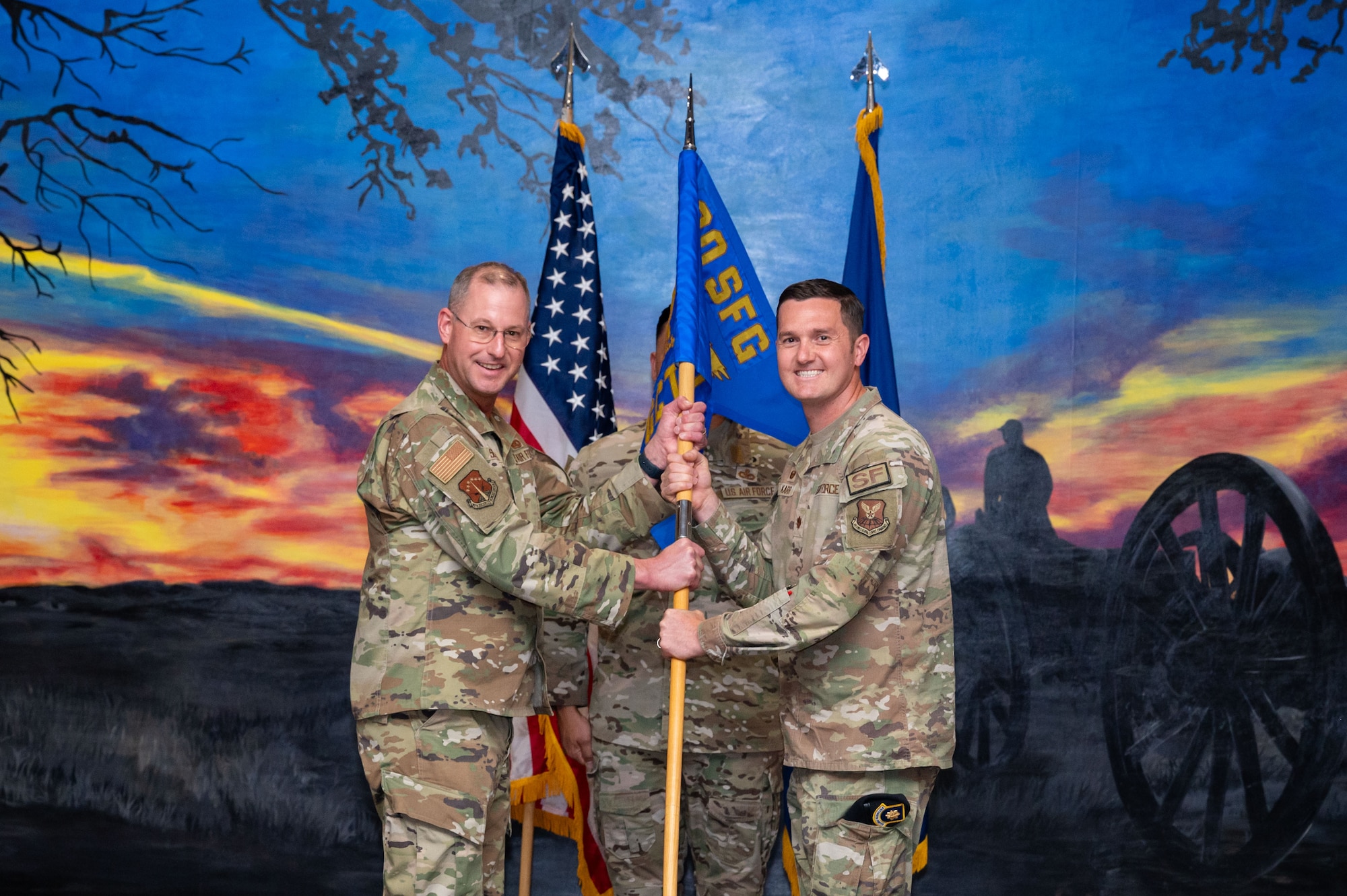 Col. Justin Secrest passes the guidon to Maj. Jeffery Karr.