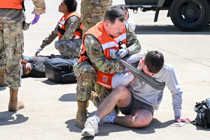 Air Force Airman wrapping a simulated injury on a volunteer during a training exercise