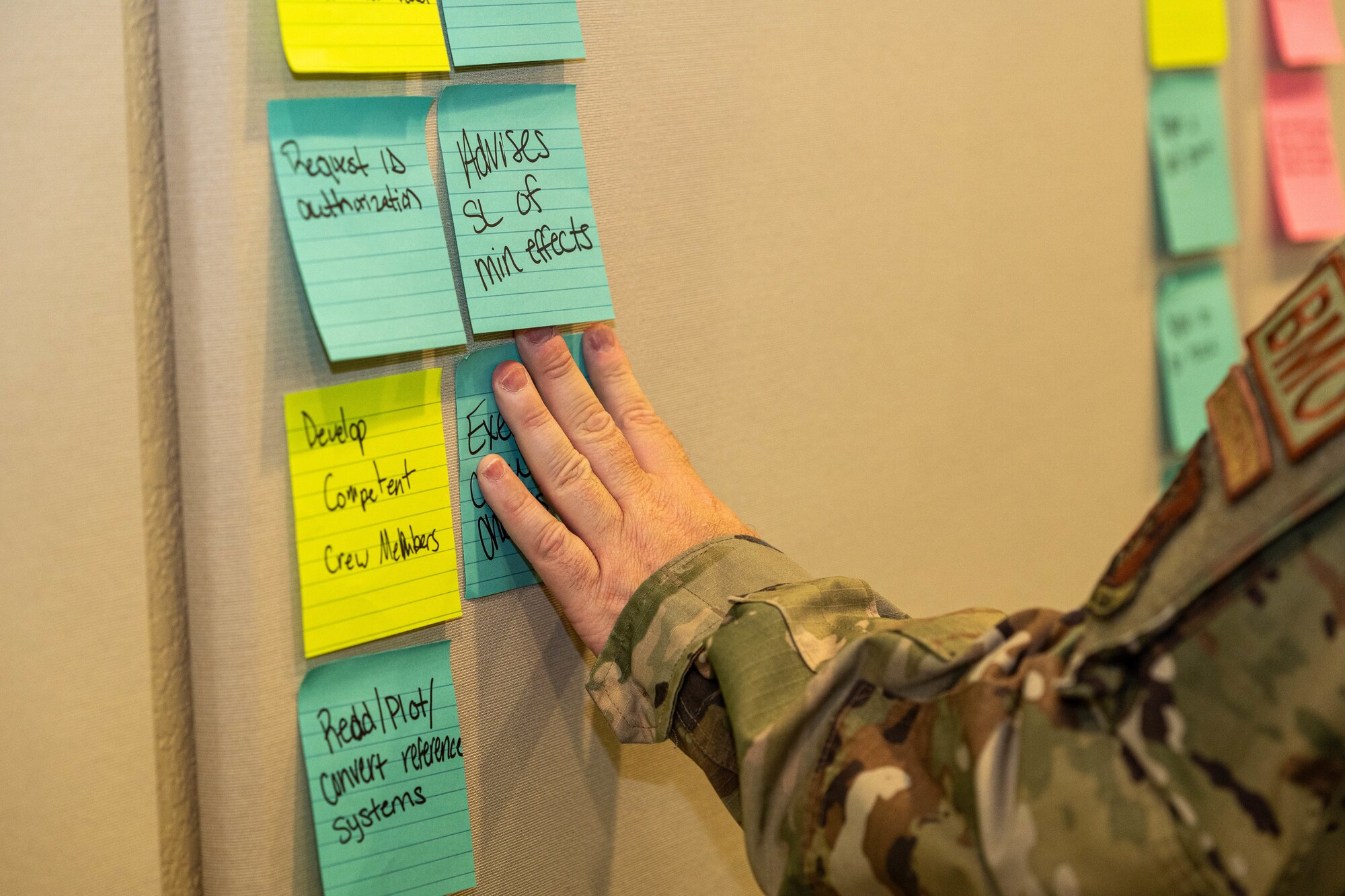 An Airman places a sticky note on a wall during a group exercise at the occupational competency seminar on Keesler Air Force Base, Mississippi, March 19, 2024.