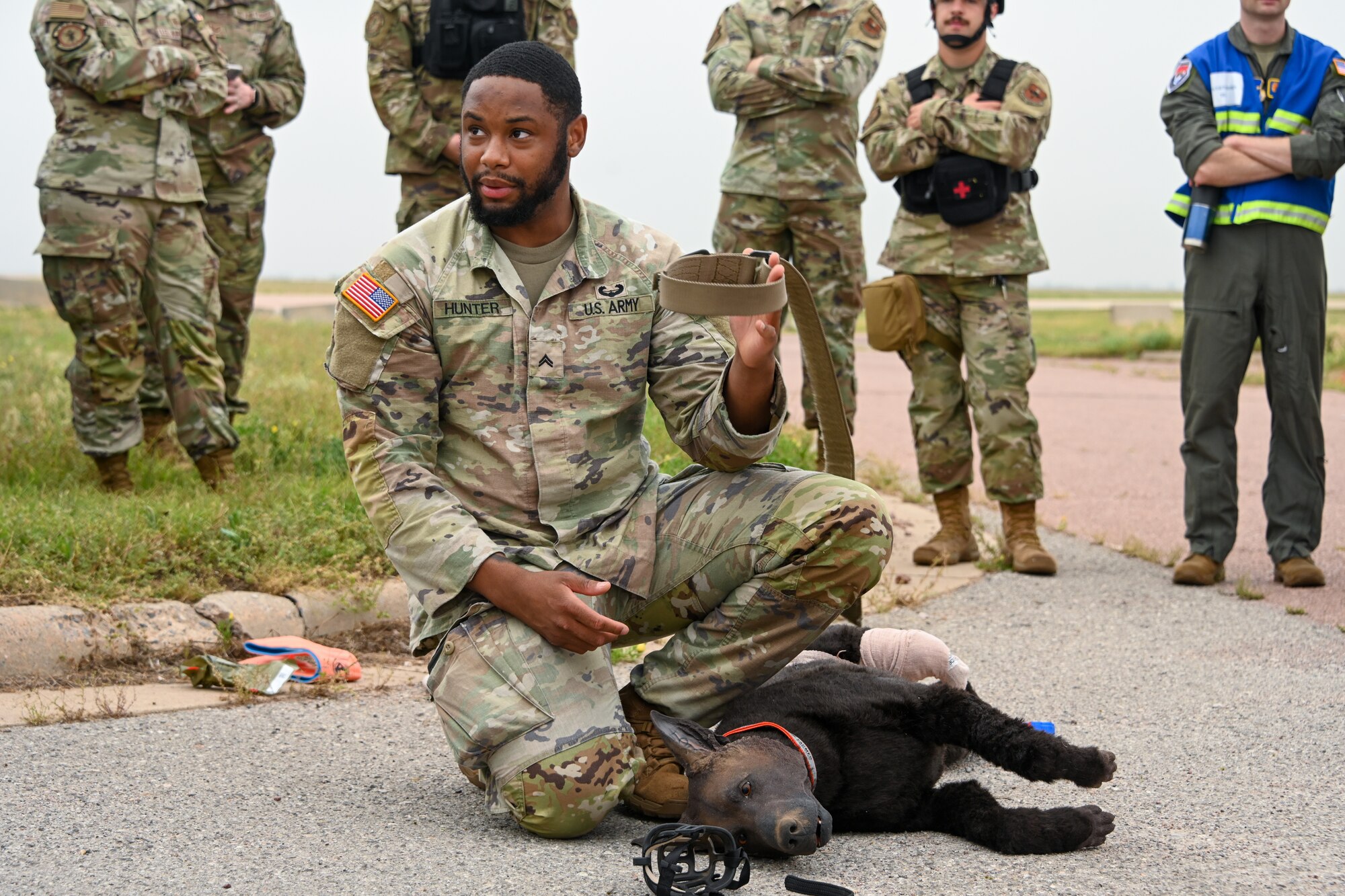U.S. Army Cpl. ZaQuan Hunter, Public Health Command animal care specialist, teaches service members how to care for a wounded canine at Altus Air Force Base, Oklahoma, May 23, 2024. Soldiers from Fort Sill brought the fake canine to demonstrate their skills. (U.S. Air Force photo by Airman Lauren Torres)