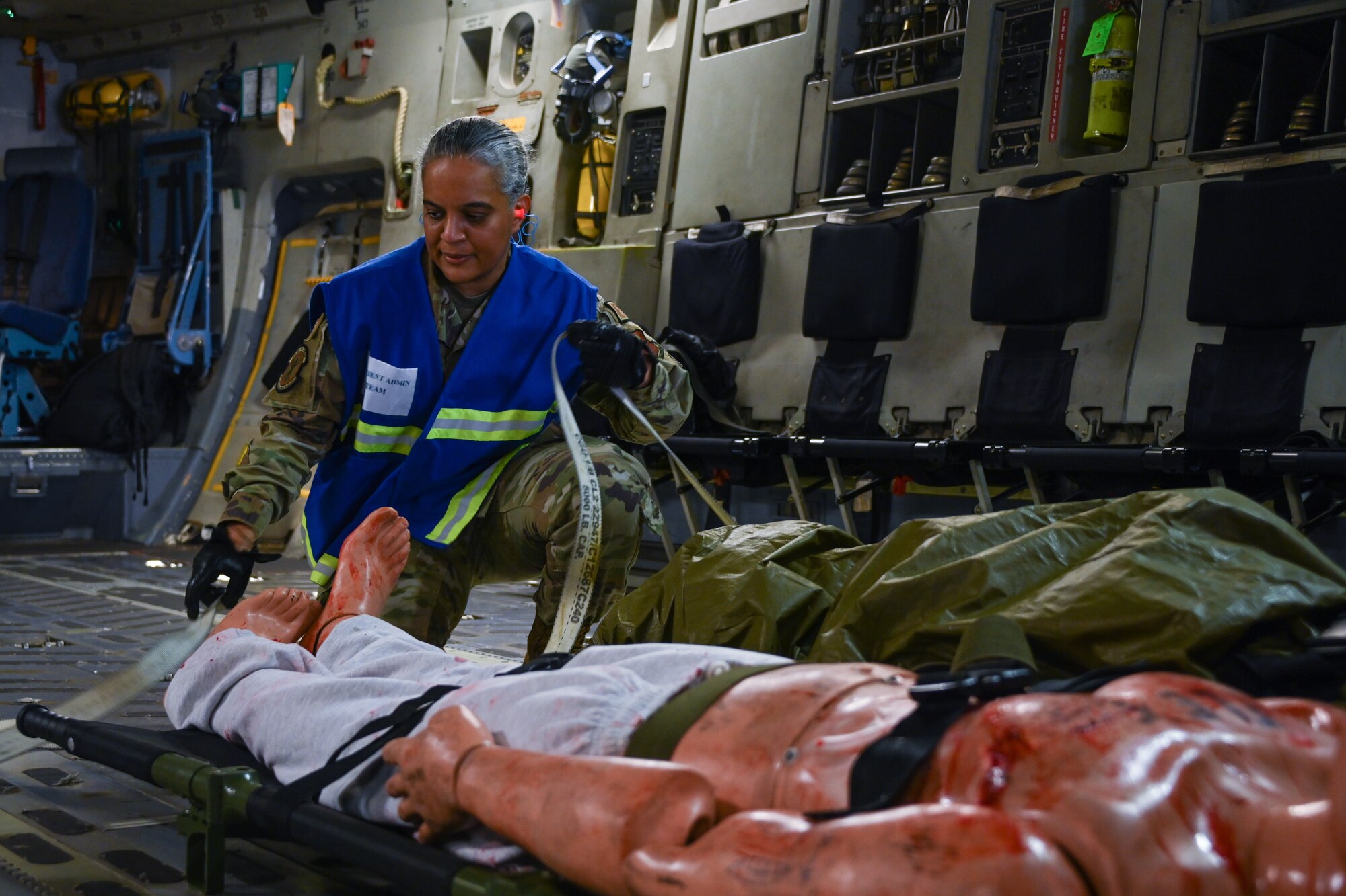U.S. Air Force Lt. Col. Shanti Jones, 97th Operational Medical Readiness Squadron commander, straps down mannequins on a C-17 Globemaster III aircraft at Altus Air Force Base, Oklahoma, May 23, 2024. Jones took the lead of Caduceus Spear and guided the service members through aeromedical evacuation. (U.S. Air Force photo by Airman Lauren Torres)