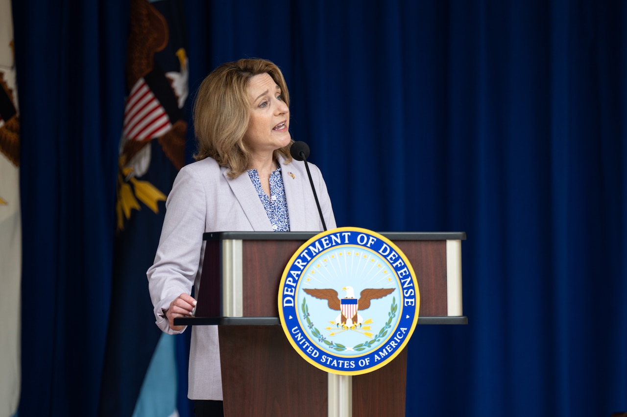A woman speaks from behind a lectern.