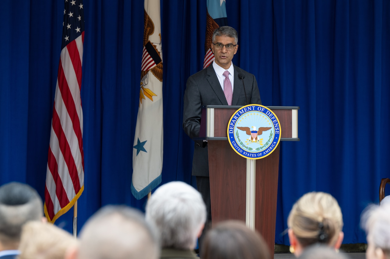 A man speaks from behind a lectern.