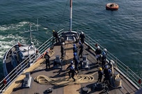 BREST, France (June 3, 2024) Sailors assigned to the Harper’s Ferry-class amphibious landing dock USS Oak Hill (LSD 51) heave a line attached to a tug boat during sea and anchor detail on the fo’c’sle during the ship’s departure from Brest, France, June 3, 2024. Oak Hill is conducting operations in U.S. Naval Forces Europe area of operations as part of the Wasp Amphibious Ready Group (WSP ARG)-24th Marine Expeditionary Unit (MEU) Special Operations Capable (SOC). The WSP ARG-24th MEU (SOC) support high-end warfighting exercises while demonstrating speed and agility operating in a dynamic security environment. (U.S. Navy photo by Mass Communication Specialist 3rd Class Justin Kemble)