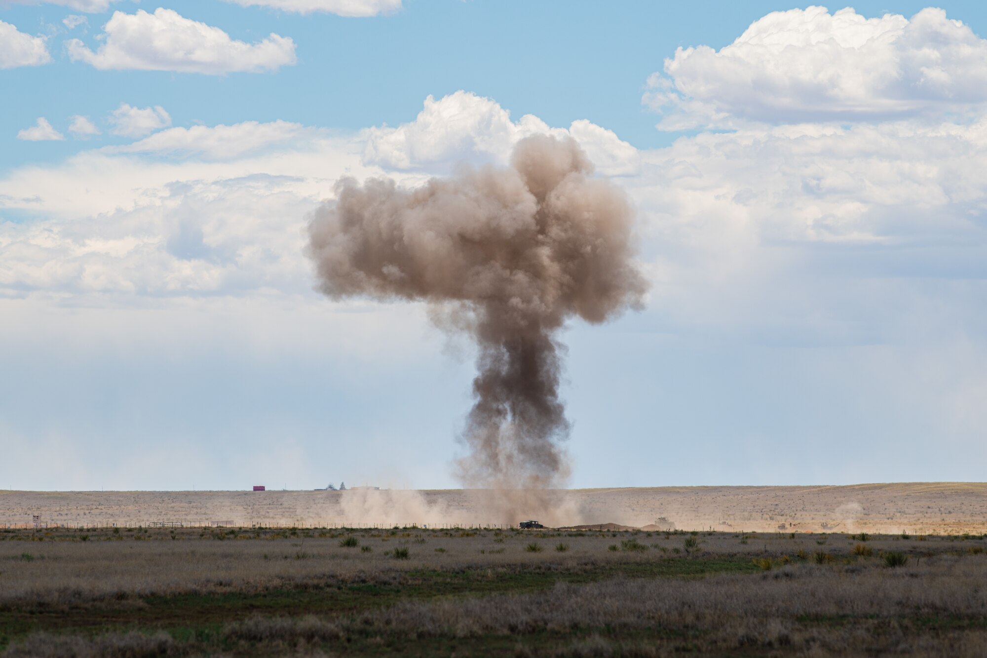A plume of smoke rises over a plain.