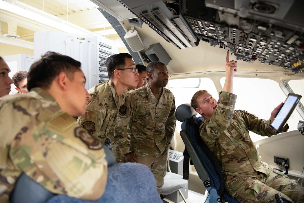 Airman teaches other Airmen inside a C17 simulator