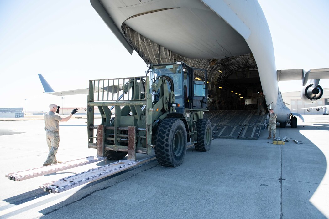 Airmen loading firklift to an airplane