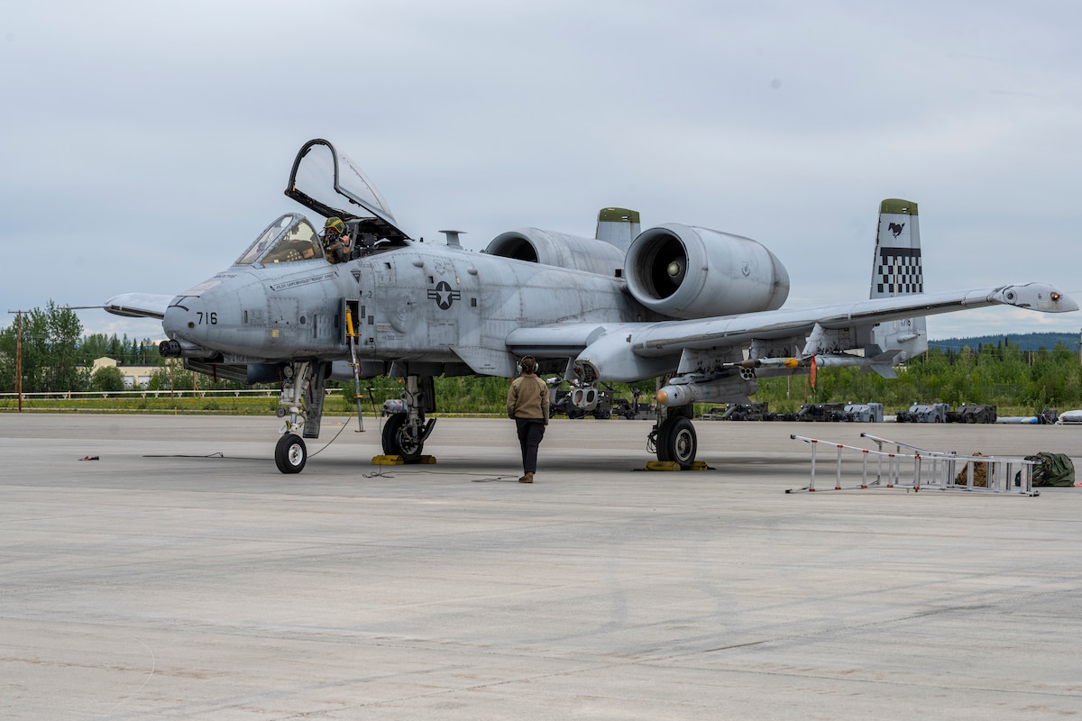 A pilot waits to be marshalled out by a maintainer in preparation for take-off.