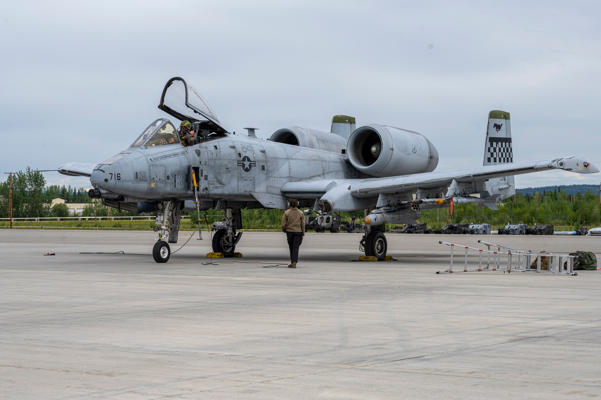 A pilot waits to be marshalled out by a maintainer in preparation for take-off.