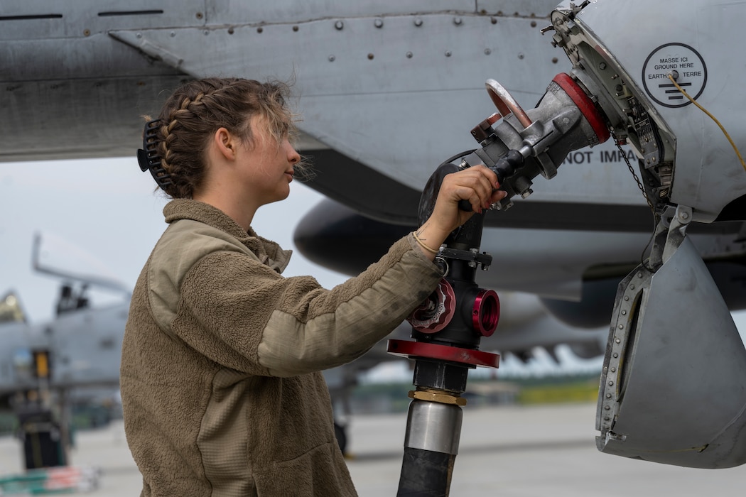A female maintainer fuels up an A-10 aircraft.
