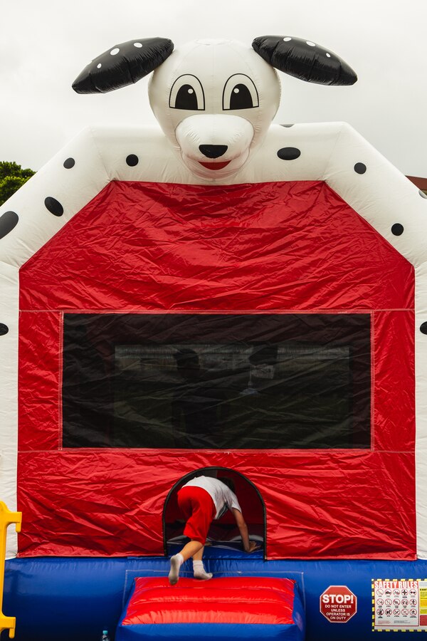 A child enters a bounce house during the 2024 Ages and Stages community event outside the Camp Foster Community Center on Okinawa, Japan, May 18, 2024. The Marine Corps Community Services New Parent Support branch hosted the event to showcase available parental resources, including parenting classes, briefings, and home visitations. (U.S. Marine Corps photo by Cpl. Jonathan Beauchamp)