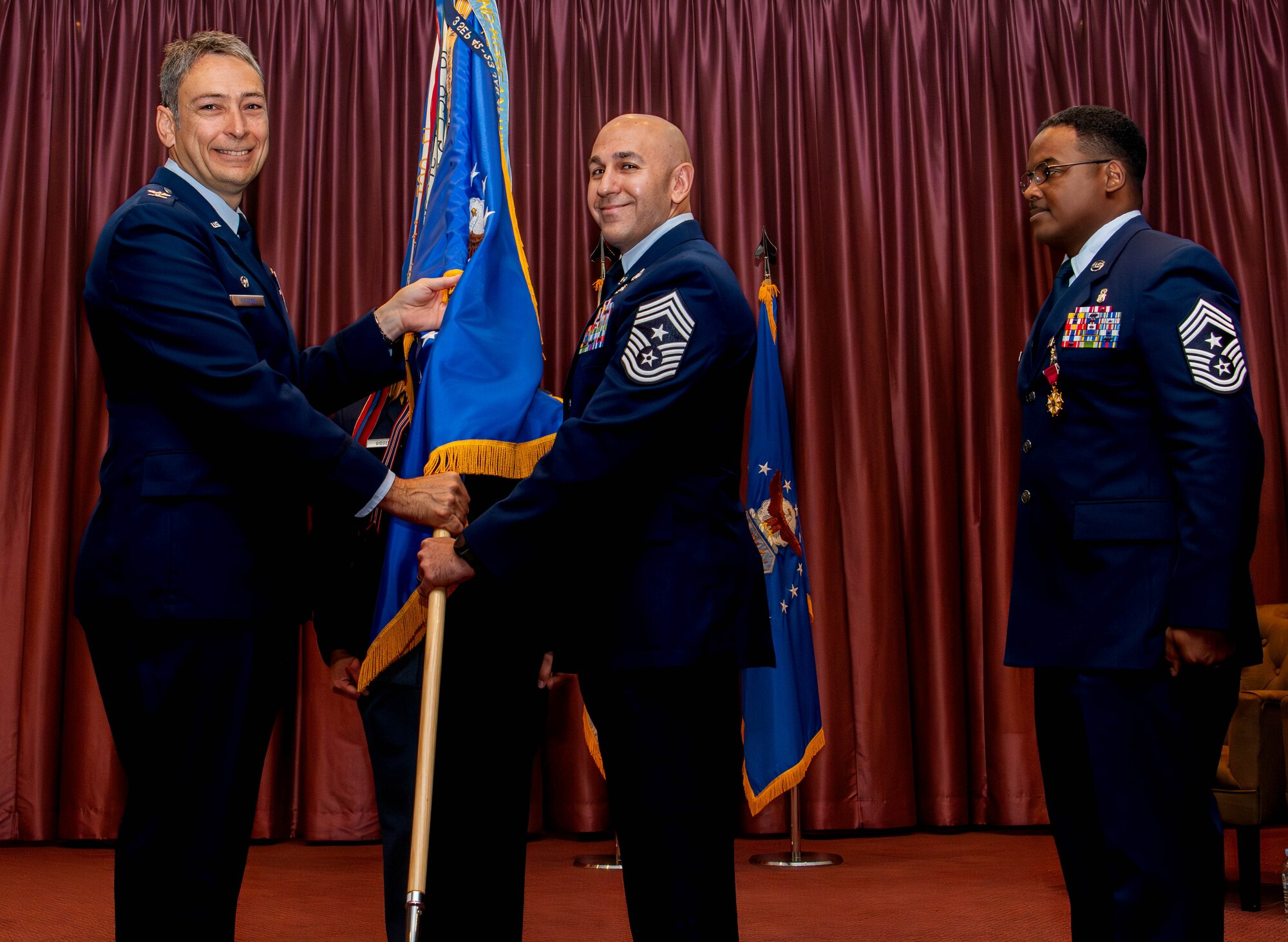 U.S. Air Force Col. Andrew Roddan, 374th Airlift Wing commander, left, presents the guidon from Chief Master Sgt. Kenneth Hauck.