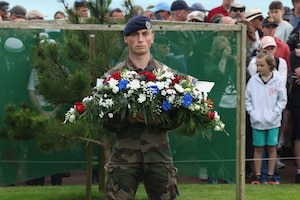 A French soldier stands with a wreath during the D-Day Memorial Ceremony at the Normandy American Cemetery in Normandy, France, June 4, 2024. U.S. Marines and sailors with 24th Marine Expeditionary Unit and members of France's 9th Marine Infantry Brigade (BIMa) gathered to commemorate the 80th anniversary of the largest amphibious operation in history. In 1944, the U.S. Army invaded the beaches of Normandy to begin the liberation of France. (U.S. Marine Corps photo by Lance Cpl. Garrett Gillespie)