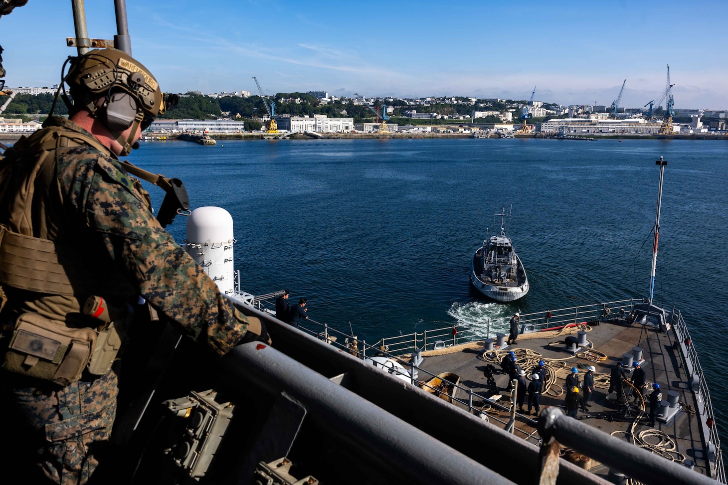 BREST, France (June 3, 2024) Lance Cpl. Warembourg, assigned to the 24th Marine Expeditionary Unit (MEU) Special Operations Capable (SOC), provides security from the bridge wing of Harper’s Ferry-class amphibious landing dock USS Oak Hill (LSD 51) while the ship’s Sailors perform sea and anchor detail on the fo’c’sle during Oak Hill’s departure from Brest, France, June 3, 2024. Oak Hill is conducting operations in U.S. Naval Forces Europe area of operations as part of the Wasp Amphibious Ready Group (WSP ARG)-24th Marine Expeditionary Unit (MEU) Special Operations Capable (SOC). The WSP ARG-24th MEU (SOC) support high-end warfighting exercises while demonstrating speed and agility operating in a dynamic security environment. (U.S. Navy photo by Mass Communication Specialist 3rd Class Justin Kemble)