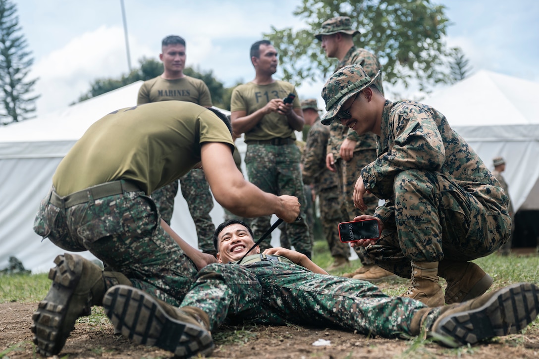 U.S. Navy Hospitalman Lorenzo DelosReyes, a corpsman with Shock Trauma Section, 1st Medical Battalion, demonstrates how to apply a tourniquet during a Tactical Combat Casualty Care subject matter expert exchange to Philippine Marines with 1st Marine Brigade for Archipelagic Coastal Defense Continuum in Barira, Philippines, May 14, 2024. TCCC teaches non-medical personnel the medical skills necessary to ensure lifesaving treatment can be rendered in the absence of a corpsman and improve the survivability of those wounded or injured in combat. ACDC is a series of bilateral exchanges and training opportunities between U.S. Marines and Philippine Marines aimed at bolstering the Philippine Marine Corps’ Coastal Defense strategy while supporting the modernization efforts of the Armed Forces of the Philippines. DelosReyes is a Manila, Philippines native. (U.S. Marine Corps photo by Sgt. Shaina Jupiter)