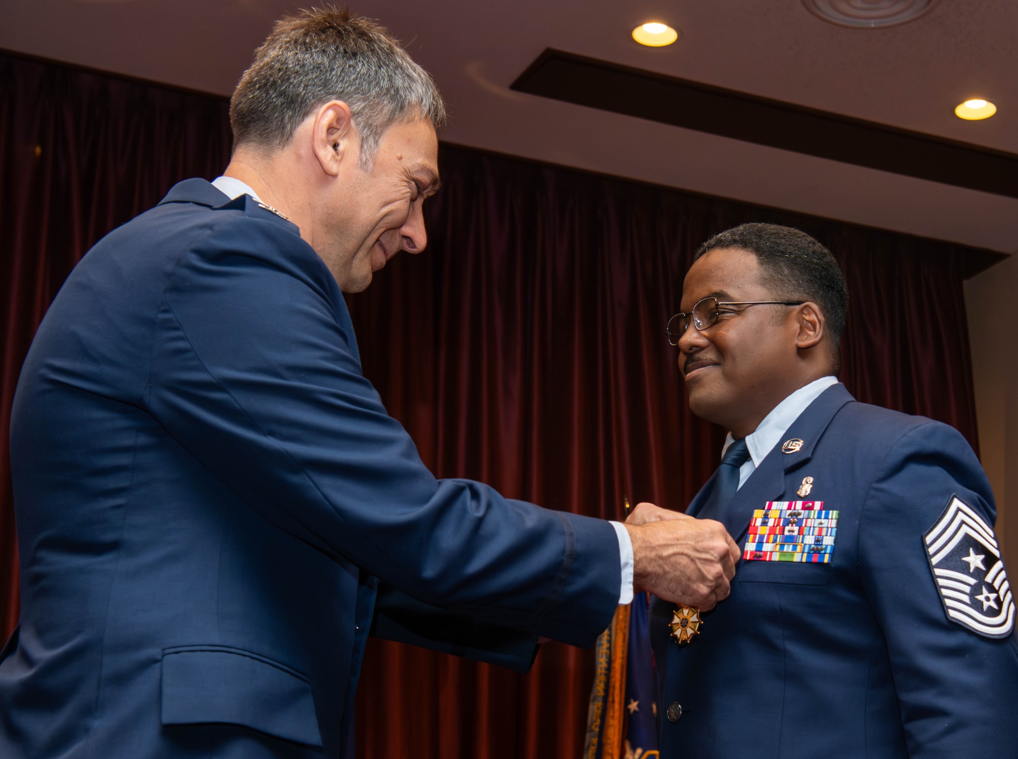 U.S. Air Force Col. Andrew Roddan, 374th Airlift Wing commander, left, awards Chief Master Sgt. Jerry Dunn, outgoing 374th AW command chief, with the Legion of Merit medal.