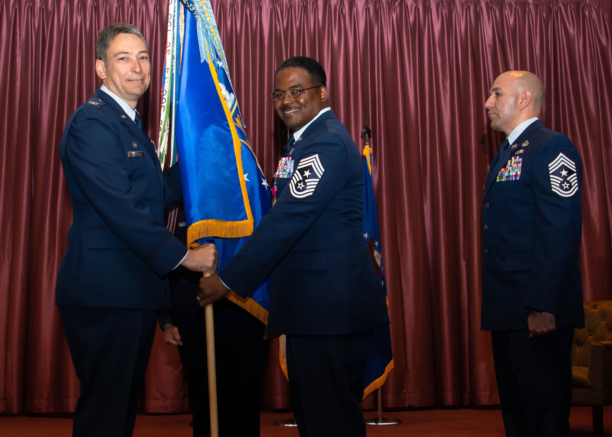 U.S. Air Force Col. Andrew Roddan, 374th Airlift Wing commander, left, receives the guidon from Chief Master Sgt. Jerry Dunn.
