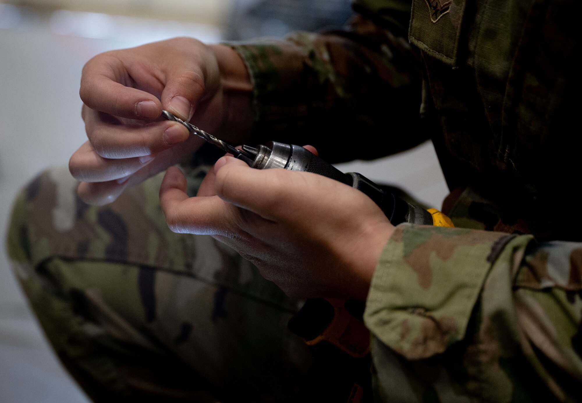 U.S. Air Force Airman Mya Camelot, 35th Maintenance Squadron aircraft structural maintenance apprentice, places a bit into a drill to conduct aircraft maintenance at Misawa Air Base, Japan, May 28, 2024.
