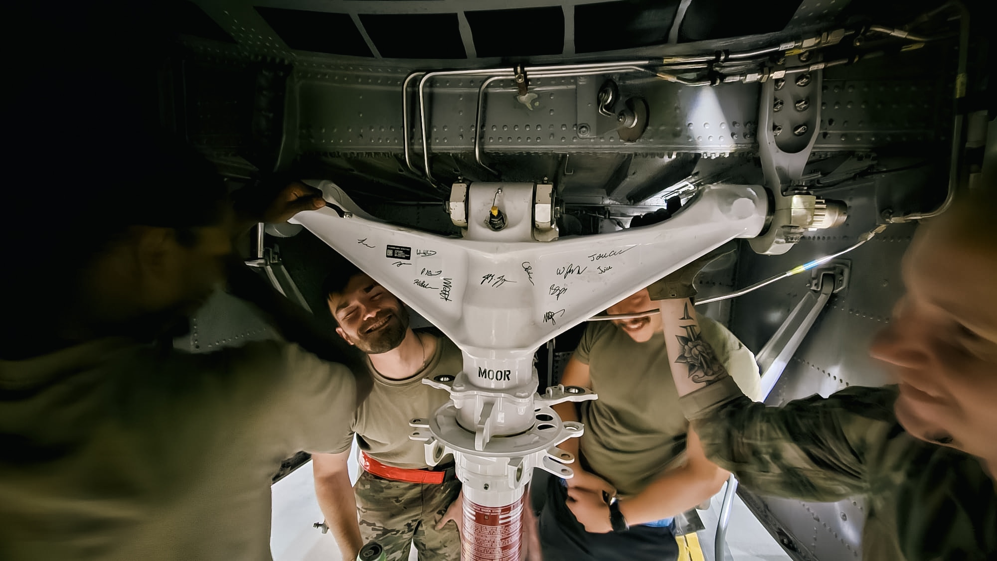 Maintenance personnel from the 41st Mission Generation Force Element laugh together as they fix a C-130J Super Hercules