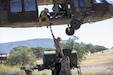 U.S. Army Soldiers with the 861st Quartermaster Company and the 25th Cavalry Division connect equipment to a UH-60 Black Hawk while conducting a sling load training pickup during the Combat Support Training Exercise at Fort Hunter Liggett, California, June 4, 2024. CSTX 24-01 is a Combat Support Training Exercise that ensures America’s Army Reserve units and Soldiers are trained and equipped at the scale and speed required to support the Joint Force, multi-domain operational environment. (U.S. Army photo by Spc. Xavier Chavez)