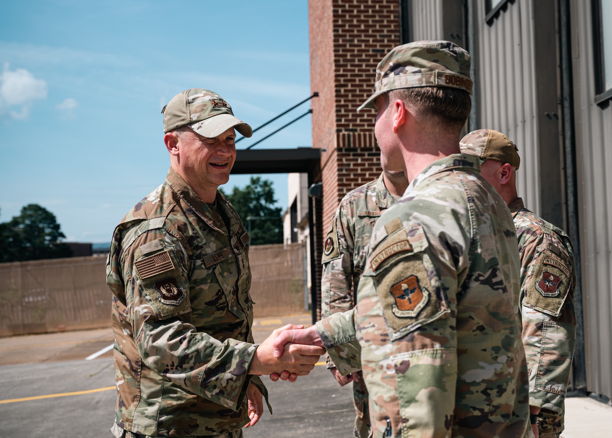 An Air Force General shakes hands with a young Airman