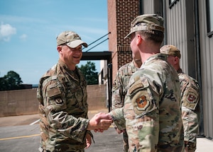 An Air Force General shakes hands with a young Airman