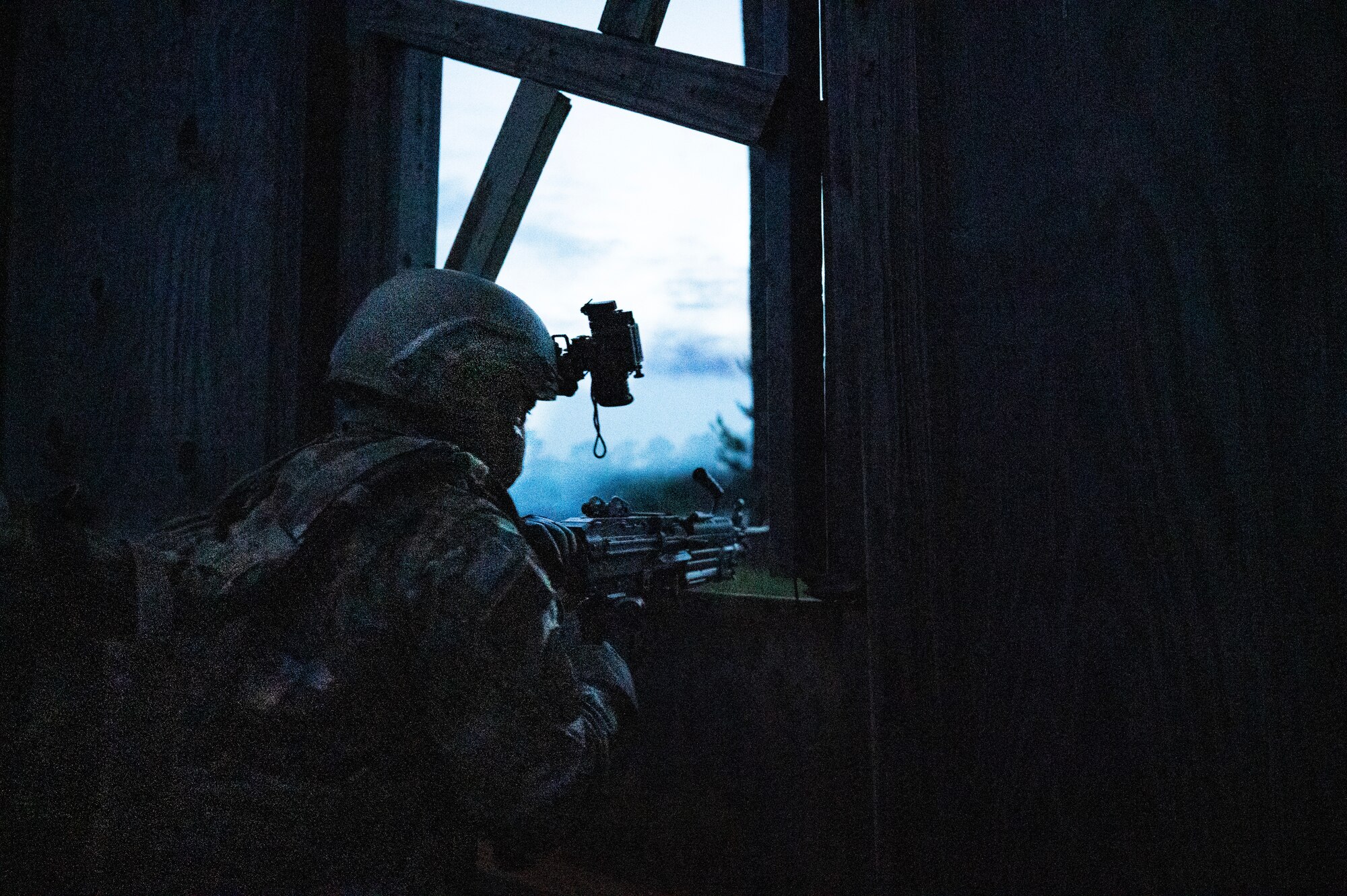 An Airman mounts his machine gun in a window and returns fire.
